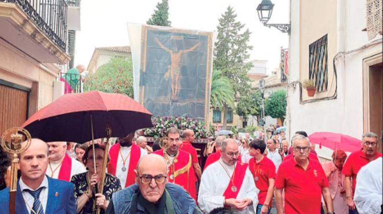 <i>El Cristo del Consuelo regresa a su templo protegido de la lluvia entre sus fieles devotos. / Ana Lechuga / Diario JAÉN. </i>