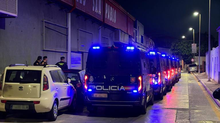<i>Furgones de la Policía Nacional preparados por si fuesen necesarios durante el traslado de migrantes. / Europa Press. </i>