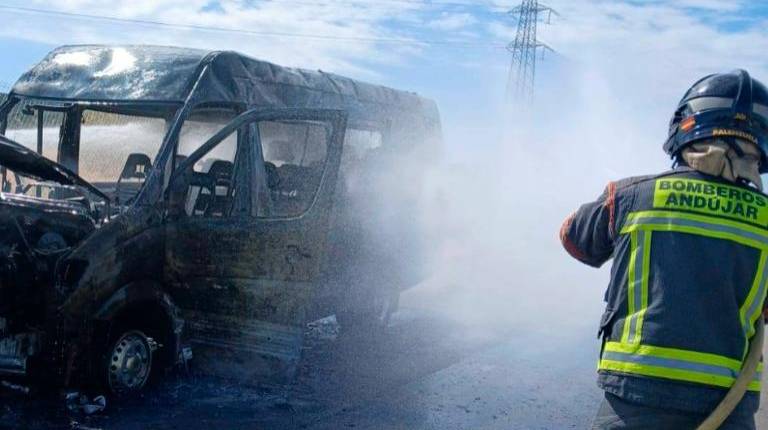<i>Un bombero extinguiendo el incendio del autobús en la A-4. / Bomberos de Andújar. </i>