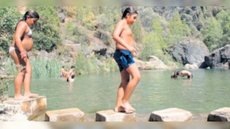 <i>Dos niños juegan en la orilla de la zona recreativa de El Charco de la Pringue, en Villanueva del Arzobispo. / Archivo histórico Diario JAÉN. </i>