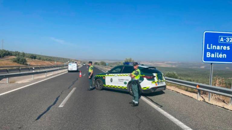 <i>Un coche patrulla de la Guardia Civil junto a dos efectivos. / Subsector de Tráfico de la Guardia Civil de Jaén. </i>