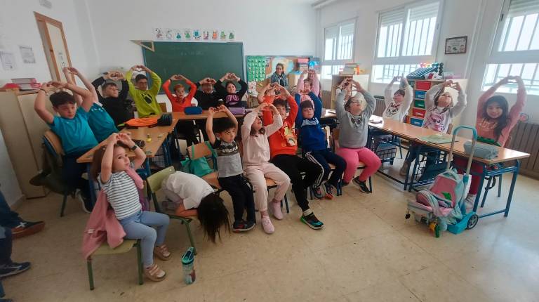 <i>Todos los alumnos del colegio alzan los brazos y hacen el gesto del corazón para decir “te quiero”. / F. Gaitán / Diario JAÉN.</i>