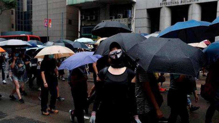 Miles de enmascarados marchan por Hong Kong