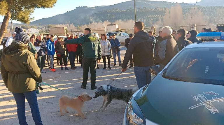 <i>Vecinos atienden las órdenes de la Guardia Civil antes de continuar la búsqueda / Fernando Cano.</i>