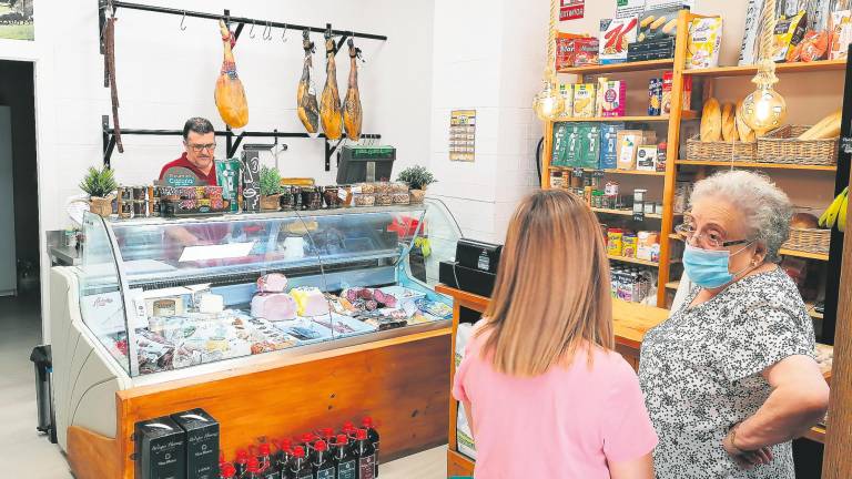 Fernando Extremera atiende a dos clientes en su tienda de jamones y embutidos con el aire acondicionado a 25 grados / Manu Ibáñez / Diario JAÉN.