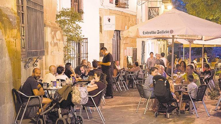 GASTRONOMÍA. <i>Vecinos toman un refrigerio en una terraza una noche veraniega.</i>