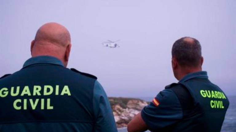 <i>Dos agentes de la Guardia Civil observan a un helicóptero. Archivo. / Gustavo de la Paz / Europa Press.</i>