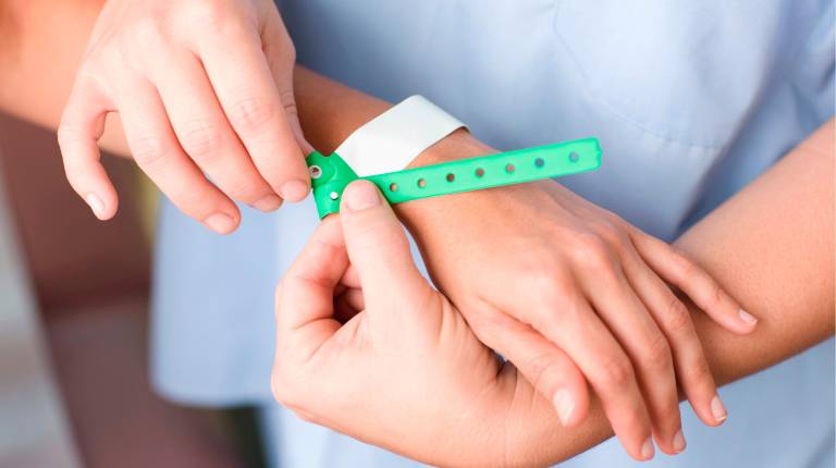 <i>Profesionales ponen la pulsera para identificar al paciente. / Junta de Andalucía.</i>