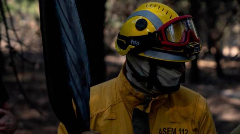 <i>Un bombero trabaja en las tareas de extinción del incendio forestal en la Sierra Oeste de Madrid, en los alrededores del Pantano de San Juan. / Matias Chiofalo / Europa Press.</i>