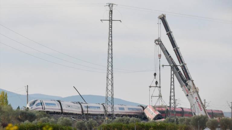 <i>Dos grúas trabajan para retirar los vagones de los trenes accidentados. / Europa Press.</i>