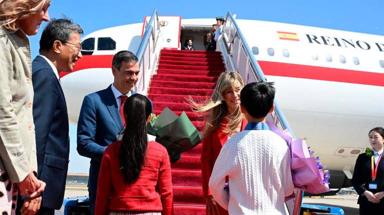<i>El presidente del Gobierno, Pedro Sánchez, acompañado de su esposa Begoña Gómez, aterriza en el Aeropuerto Internacional de Pekín.</i>
