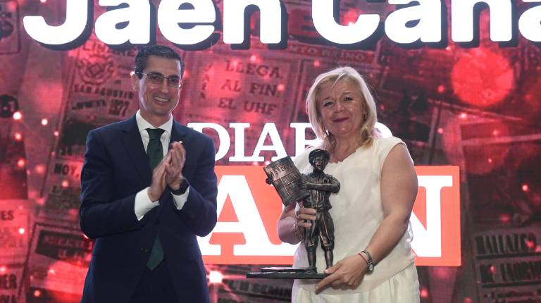 <i>El director general de Caja Rural de Jaén, Fernando Planelles, entrega el Premio Iniciativa a María Dolores Jaén sobre el escenario instalado en el Olivo Arena. / Agustín Muñoz / Diario JAÉN.</i>