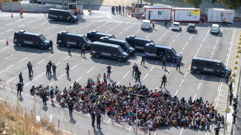 <i>Migrantes desalojados de la playa del Trampolín de camino a ser reubicados. / Europa Press. </i>