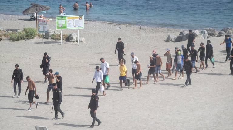 <i>Varios migrantes entran por las costas de Ceuta en una imagen de estos días. / Marcos Moreno / Europa Press.</i>