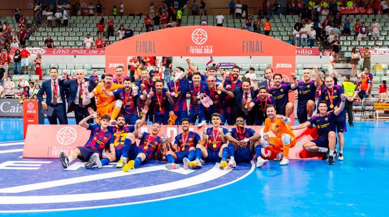 <i>Antonio Pérez, sentado, celebra entre Adolfo y el francés Touré el título de Liga en la forto de familia del Barça. / RFEF.</i>