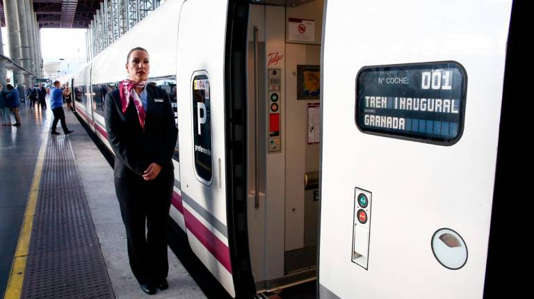 <span class=mln_uppercase_mln>TODO LISTO. </span><i>Una azafata espera en el andén, junto a unos de los vagones del AVE que conecta Granada con Madrid. </i>