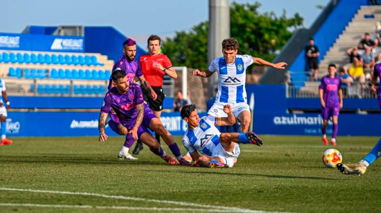 <i>El jugador del Real Jaén Adri Paz pugna un balón con dos rivales del Atlético Baleares. / Miranda López / Real Jaén CF</i>