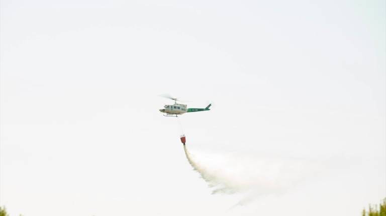 <i>Un helicóptero participa en las tareas de extinción de un incendio forestal. / Europa Press.</i>