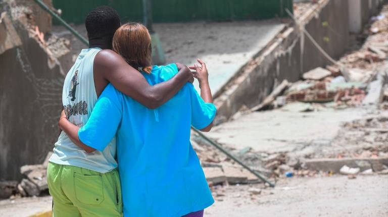 <i>Una pareja se abraza frente a un edificio derrumbado en La Guaira, Venezuela. / Marcos Salgado / Contacto / Europa Press.</i>