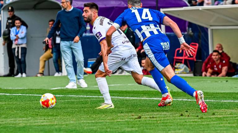 <i>Mario Martos conduce el balón en presencia de Iban Garrido. / Miranda López / Real Jaén.</i>