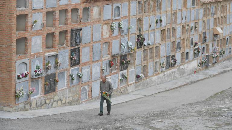 Un hombre camina con un ramo de flores en el cementerio de San Eufrasio, en Jaén. / Agustín Muñoz / Diario JAÉN. 