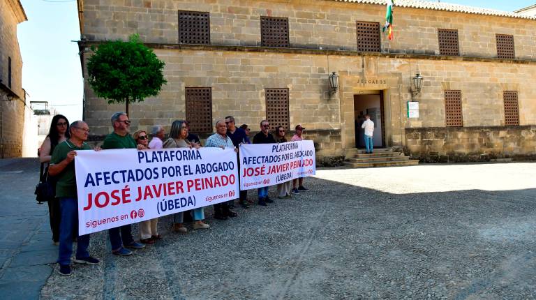 <i>Un grupo de víctimas sostiene la pancarta recién estrenada de la Plataforma de Afectados por el Abogado José Javier Peinado. / Jesús Delgado / Inmaculada Cejudo.</i>