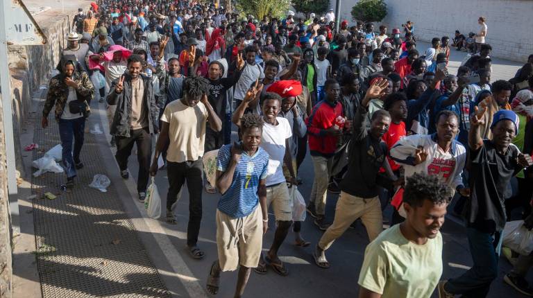 <i>Migrantes desalojados de la playa del Trampolín de camino a ser reubicados. / Europa Press. </i>