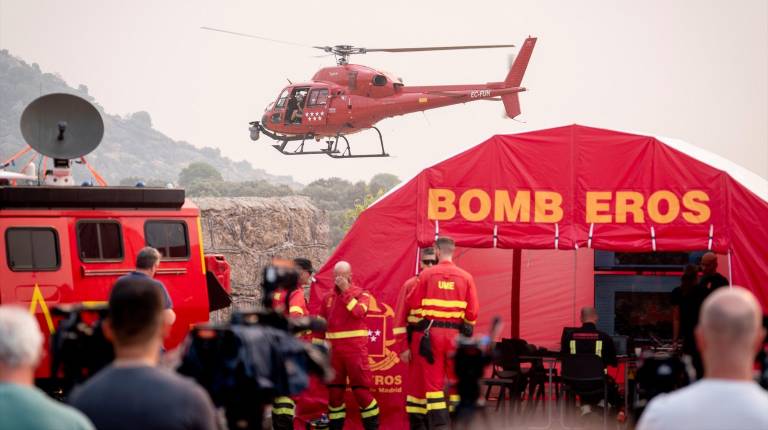 <i>Helicóptero de Emergencias de la Comunidad de Madrid y puesto de bomberos en el Puesto de Mando Avanzado de la zona afectada por los incendios forestales de la sierra oeste. / A. Pérez Meca / Europa Press. </i>