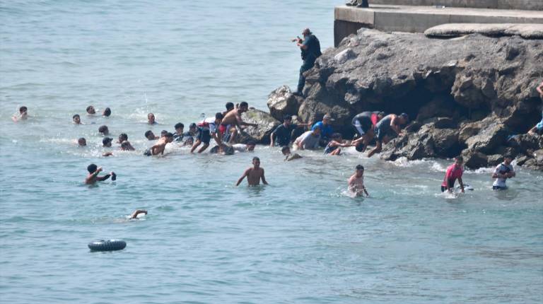 <i>Varias personas intentan cruzar la frontera a nado. / Europa Press. </i>