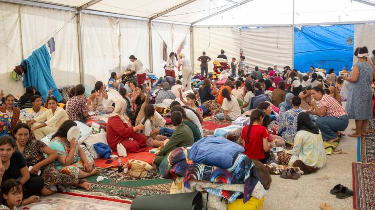 <i>Varios menores migrantes se refugian bajo una carpa. / Europa Press. </i>