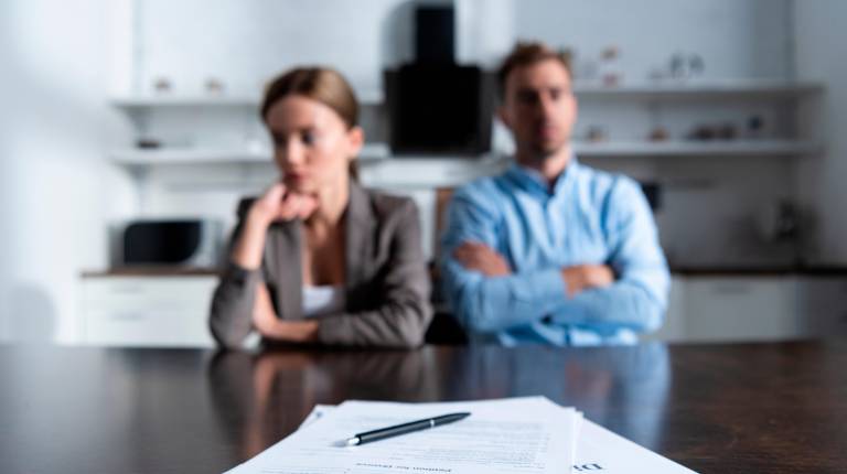 <i>Una mujer y un hombre dejan sus anillos de compromiso después de firmar una demanda de divorcio.</i>