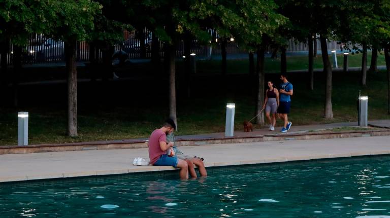 <i>Dos jóvenes se refugian del calor en el Bulevar de Jaén. Archivo. / Jason Moyano / Diario JAÉN.</i>