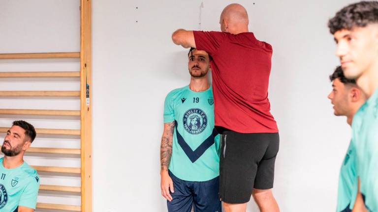 Leo Fuentes, preparador de porteros, mide al delantero Agus Alonso. / Miranda López / Real Jaén.