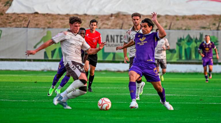 <i>El delantero del Real Jaén Marco Siverio intenta zafarse de un rival del Antequera en el centro del campo. / Miranda López / Real Jaén CF.</i>