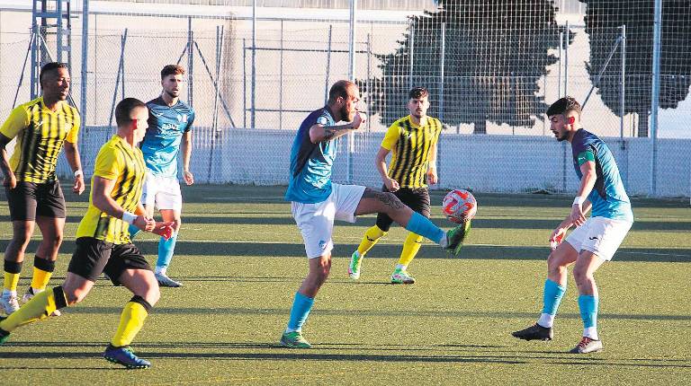 <i>Tarón, del Villacarillo, controla un balón ante jugadores del Cubillas de Albolote. / Fernado Cano / Diario JAÉN.</i>