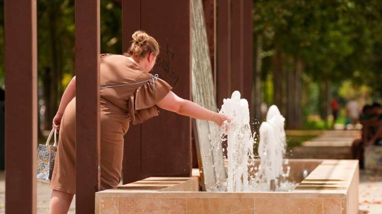 <i>Una mujer se refresca en una fuente. / María José López / Europa Press. </i>