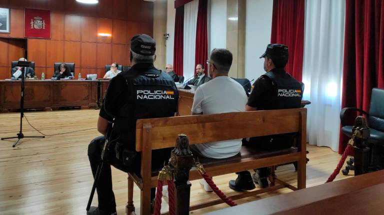 <i>El acusado franqueado por dos policías durante el juicio. / Europa Press. </i>