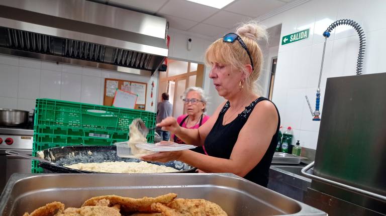 <i>Una voluntaria de Cáritas Interparroquial de Linares prepara uno de los menús que reparte a diario el Comedor Social San Agustín. / Fran Miranda / Diario JAÉN. </i>
