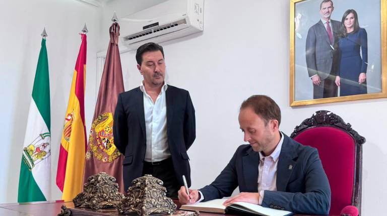 <i>Erik Domínguez firmando el Libro de Honor en La Carolina junto al alcalde del municipio, Cristobal Pérez. / Junta de Andalucía. </i>