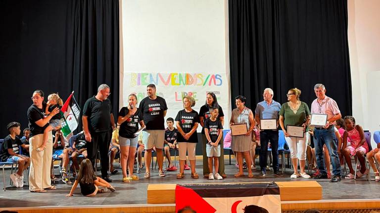 <i>Las seis familias de acogida de Jódar sobre el escenario junto con las personas reconocidas como madrinas y padrinos de honor de la Asociación Amigos del Sáhara Libre.</i>
