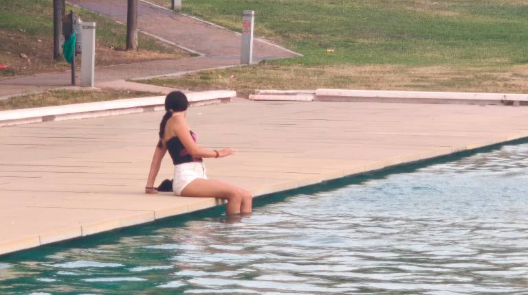 <i>Una chica se moja las piernas para refrescarse en una jornada de intenso calor. / Agustín Muñoz / Diario JAÉN</i>