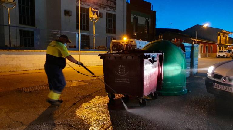 SERVICIOS<i>. Un operario trabaja en la desinfección de contenedores situados en la vía pública.</i>