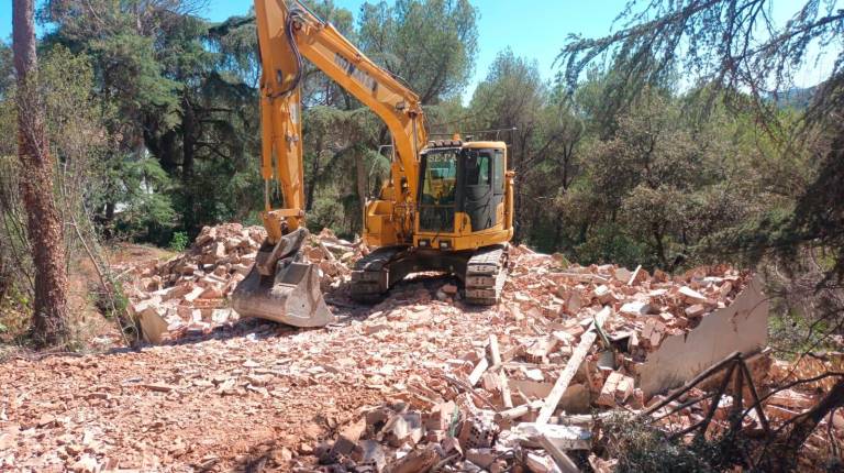 <i>Una máquina pesada, en el centro de la vivienda después de proceder a su hundimiento en la parte alta del Poblado del Guadalmena. / Joaquín Castillo.</i>