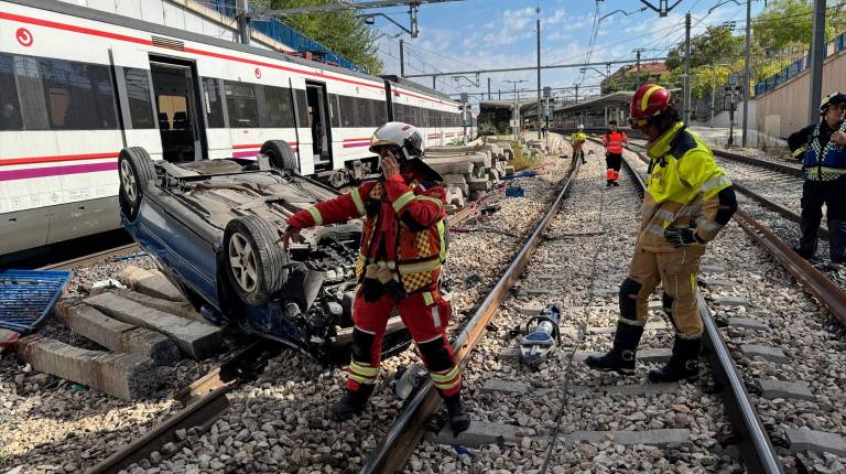 <i>Un turismo se precipita desde un puente hacia las vías de la estación de Cercanías de Fuenlabrada. / Emergencias 112 Comunidad de Madrid</i>