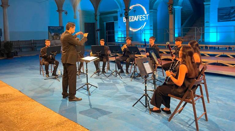 <i>Los vientos de la Orquesta de la Universidad de Jaén interpretan su programa rodeados de la belleza patrimonial de la Antigua Universidad de Baeza. / Ana Lechuga.</i>