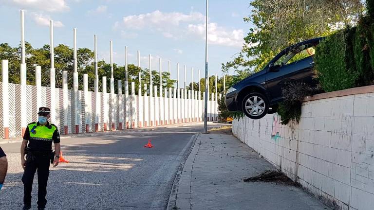 Peculiar accidente: medio coche queda suspendido en el aire