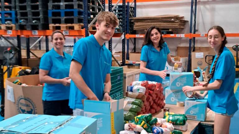 Varios voluntarios de Fundación La Caixa ordenan productos en el Banco de Alimentos de Jaén.