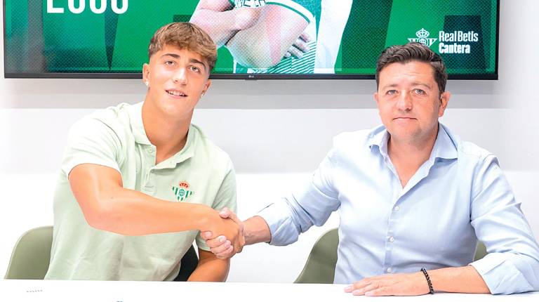 <i>Rafa Oya y Miguel Calzado se saludan tras rubricarse la renovación. / Real Betis.</i>