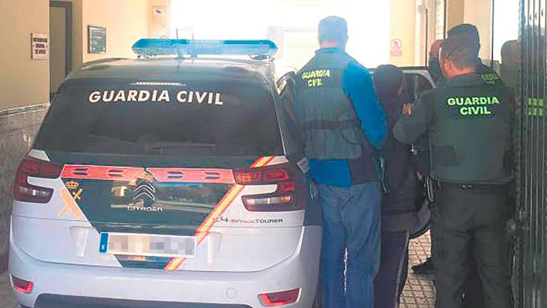 Agentes de la Guardia Civil se disponen a introducir al sospechoso en un coche del cuerpo.