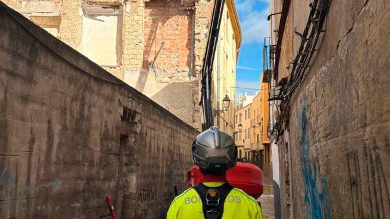 Los bomberos atienden un desprendimiento de piedras del muro de una casa en Merced Alta